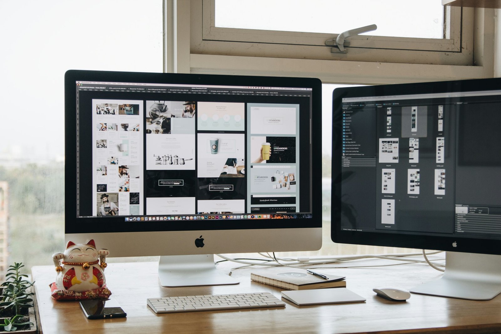Escritorio con dos monitores mostrando diseño web